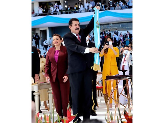Mel Zelaya muestra la nueva banda presidencial elaborada en podesua de seda color turquesa con el escudo bordado con hilos de sedas y detalles con hilos de oro y flecos metálicos elaborada por María de los Ángeles Moncada.