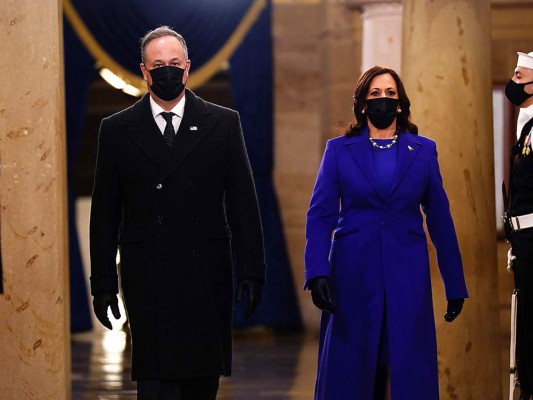 Doug Emhoff vestido de Ralph Lauren y su esposa, la vicepresidenta Kamala Harris, quien optó por llevar un suit firmado por el joven diseñador afroamericano, Christopher John Rogers (Photo by JIM LO SCALZO / POOL / AFP)