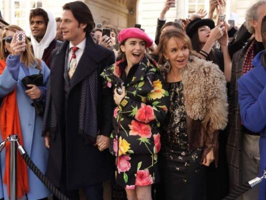 En un desfile vemos a Emily luciendo un vestido y un abrigo acolchado con estampado de flores, combinados con una linda boina rosa.