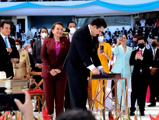Manuel Zelaya se prepara para colocar la banda presidencial a su esposa mientras sus hijos y nietos registran ese momento especial