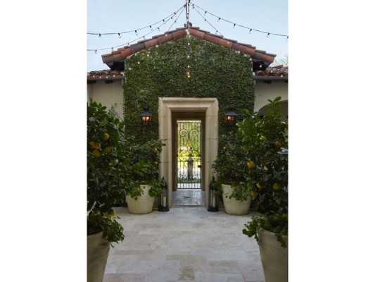 La entrada de la casa, con la fachada cubierta de hiedra y abundante naturaleza