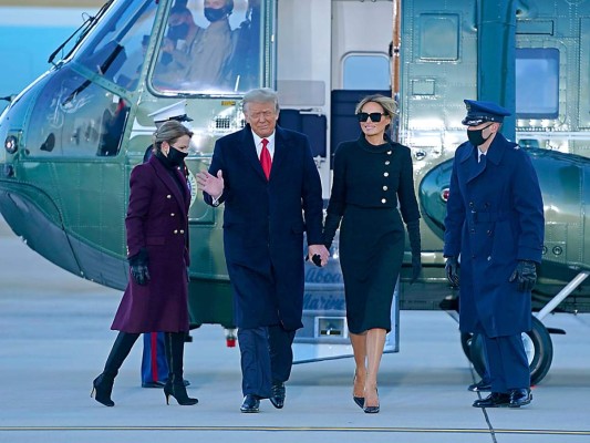 El presidente saliente Donald Trump y su esposa Melania descienden del helicóptero que los trasladó a la base aérea en Maryland