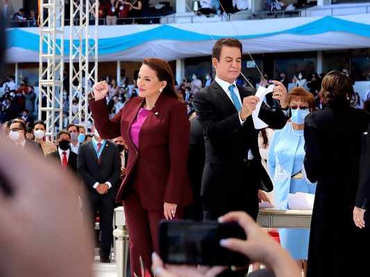 La mandataria levanta el puño en un gesto de alegría y victoria. En el escenario los vicepresidentes Salvador Nasralla y Doris Gutiérrez