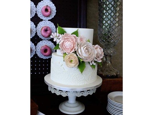 Pastel de dos niveles con una decoración de rosas.