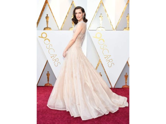 Con aires vintage Allison Williams, llegó a la entrega de los premios Oscar con un estilo muy marcado por sus líneas vintage de Armani Privé, ajustado en la zona del cuerpo y con caída muy fluida con mucho volumen. La organza de la falda le da un toque semitransparente muy de tendencia y el escote en red metalizada.<br/>