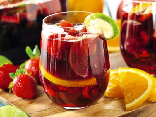 Sangría con champagne<br/>Ingredientes. Una botella de champagne. Un limón. Un par de naranjas. Un melocotón. Cinco fresas. Dos cucharadas soperas de azúcar. 50 ml de vino tinto. Hielo<br/><br/>Preparación. Lava y corta muy bien las naranjas, melocotón y fresas, más o menos del mismo tamaño, excepto una de las naranjas que la reservaremos para después. Coloca todo en una jarra, exprimiendo el zumo de la última naranja y el del limón para crear algo de zumo, remueve bien y refrigera unos minutos antes de servir.<br/>