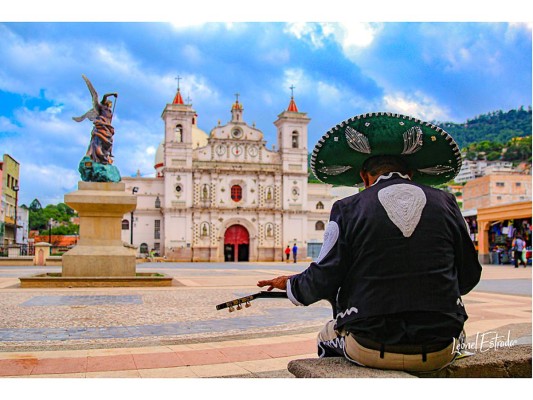 Con la fe puesta en el nuevo día, un mariachi espera el momento de cantar frente a la Iglesia Los Dolores en la plaza del mismo nombre