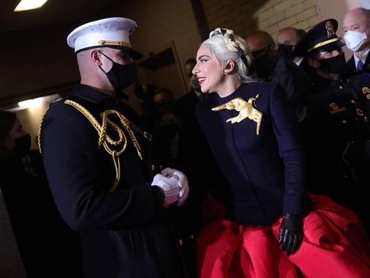 La cantante conversa con su escolta momentos antes de su interpretación del himno nacional en la ceremonia en la que Joe Biden se convirtió en el 46 presidente de los Estados Unidos. Photo by Win McNamee/Getty Images/AFP<br/><br/>