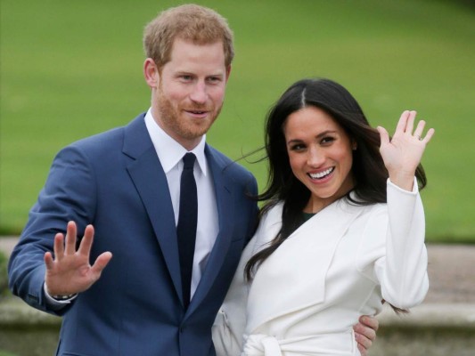 (FILES) In this file photo taken on November 27, 2017 Britain's Prince Harry and his fiancée US actress Meghan Markle pose for a photograph in the Sunken Garden at Kensington Palace in west London, following the announcement of their engagement. - Britain's Prince Harry and his wife Meghan will step back as senior members of the royal family and spend more time in North America, the couple said in a historic statement Wednesday. (Photo by Daniel LEAL-OLIVAS / AFP)
