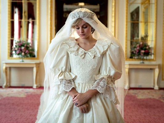 Un vestido inolvidable. Todo esperamos ver ese momento en el que la serie nos transporte al 29 de julio de 1981, el día memorable en el que el mundo siguió paso a paso la boda entre el príncipe Carlos y Diana Spencer. Su vestido quedó grabado en la retina colectiva y The Crown recrea ese momento de forma espectacular. Sidonie Roberts, asistente de diseño de vestuario y jefa de compras, explica que fue muy interesante determinar qué diseños debían reproducir de la manera más fiel posible y cuáles podían crear de cero para la serie. ‘Hubo momentos clave en los que nos limitados a recrear looks icónicos que lució, por ejemplo, el vestido de novia, para el que contamos con la inestimable generosidad de David Emanuel (el diseñador original) o el traje de compromiso ready-to-wear que Diana compró a Harrods. Esta decisión también significaba que luego teníamos una licencia más creativa cuando se trata de crear el vestuario de los momentos públicos menos conocidos o espacios privados más tranquilos’, explica Sidonie.