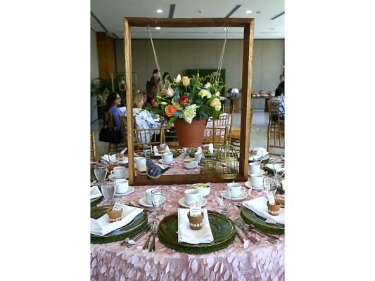 Bases de madera con hermosos arreglos de rosas, hortensias perfumaron el cálido ambiente de jardín dispuesto para la ocasión.