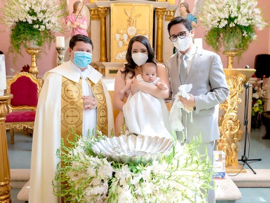 Aitana Valentina junto a sus padres y el sacerdote Cecilio frente al Santísimo