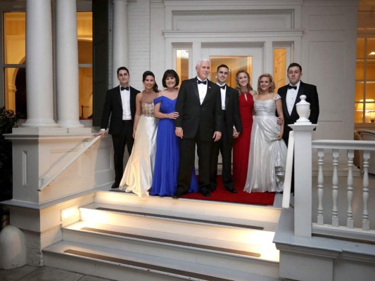 El vice presidente Mike Pence, su esposa Karen Pence, sus hijas Audrey, Charlottey su hijo Michael y su esposa Sarah posan para fotografías en el porche de la residenciaantes de dirigirse al baile de inuguración.