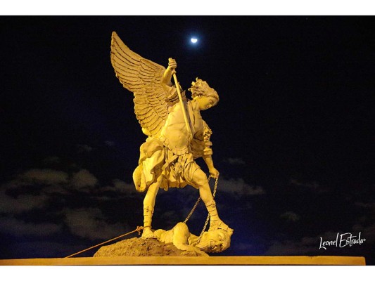 Una escultura de San Miguel Arcángel elaborada en bronce, hierro y cobre y colocada sobre una base de concreto, escolta día y noche el templo de Los Dolores