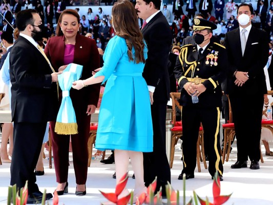 Luis Redondo sostiene la banda presidencial mientras lo rodean la presidenta Iris Castro, Mel Zelaya e Irene Melara