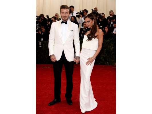 David Beckham en un suit de Ralph Lauren y Victoria Beckham en un vestido blanco de su firma homónima en la gala de 2014