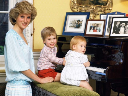 Diana y sus hijos, William y Harry, posan frente al piano en Kensington Palace en 1985