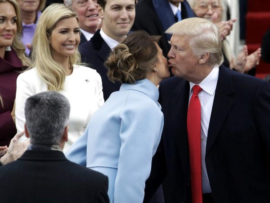 Un beso entre el mandataio Trump y su esposa Melania, ante la sonrisa de Ivanka Trump