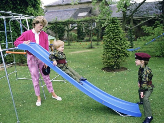 La princesa de Gales juega con sus hijos, vestidos con uniformes del Parachute Regiment, en los jardines de Highgrove.