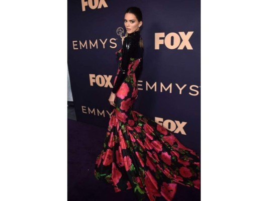 Look por Richard Quinn, con un top de cuello alto de latex negro, bajo con un vestido de estampado de flores, look muy acorde a la temporada.