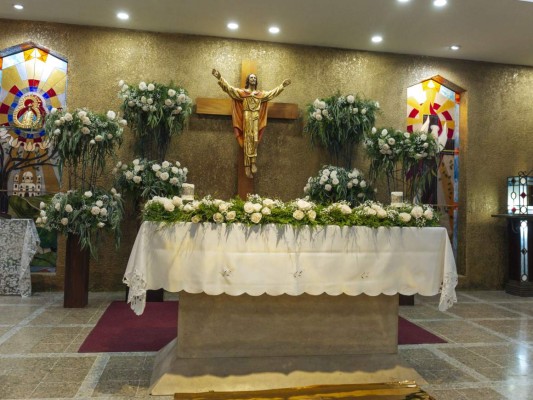 Altar delicadamente decorado con masivos arreglos con rosas, baby breath y helechos.