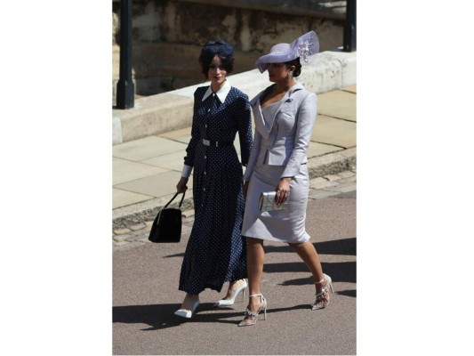 Dos grandes amigas de Meghan Markle, Abigail Spencer (izquierda) vestía un vestido largo de lunares muy en tendencia de la firma Alessandra Rich, con un tocado de flores, el bolso de mano inglés y ese cinturón que ciñe el vestido y a la derecha Priyanka Chopra.