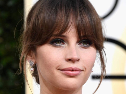 Felicity Jones<br/>La joven protagonista de Rogue One llevó un recogido con fleco, smokey eyes en gris metalizado y labios nude.