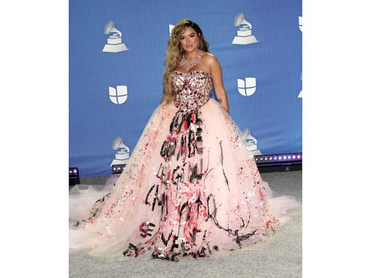 La colombiana Karol G lució un vestido con muchos elementos que no le favorecía, incrustaciones de piedras en el área del torso con una amplia falda con letras escritas en la parte frontal, realmente no se logró saber cuál era su objetivo con ese vestido. ¡Abrumador!