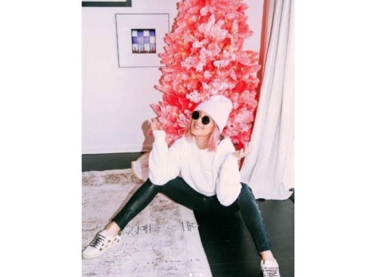 Ashley Tisdale posando junto a su árbol de navidad que curiosamente combinaba con su cabello.