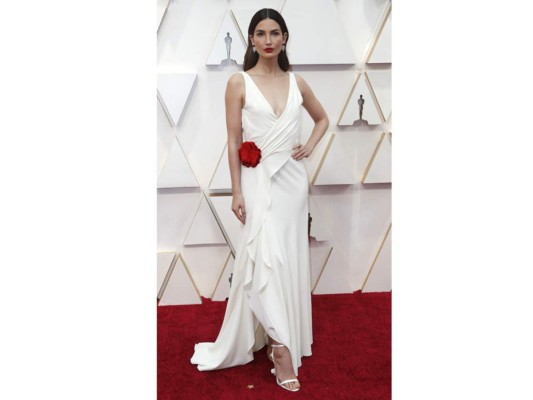 Lily Aldridge, lució un vestido en crepe blanco drapeado, con un gran escote V y detalle de una gran rosa roja en el costado. Un diseño by Ralph Lauren.<br/>