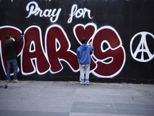 Dos jóvenes elaboran un mural 'Pray for Paris' en tributo a las víctimas de los atentados de París