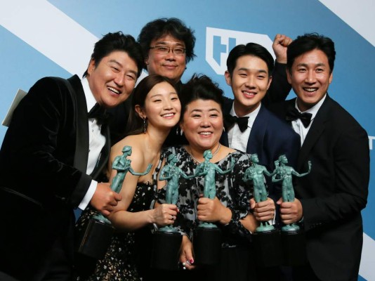 TOPSHOT - 'Parasite' cast (L-R) Song Kang-ho, Cho Yeo-jeong, director Bong Joon-ho, Lee Jung-eun, Choi Woo-shik, and Lee Sun-kyun pose with the trophy for Outstanding Performance by a Cast in a Motion Picture in the press room during the 26th Annual Screen Actors Guild Awards at the Shrine Auditorium in Los Angeles on January 19, 2020. (Photo by Jean-Baptiste Lacroix / AFP)