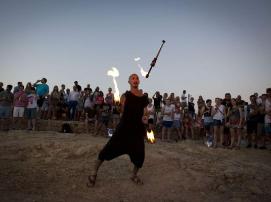 Un malabarista de fuego se presenta en el Café del Mar en San Antonio de Portmany en la isla de Ibiza. El legendario bar abrió sus puertas en 1980 y ya suma 35 años al servicio de los turistas que visitan la isla.