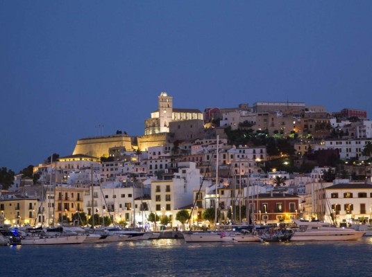 Vista nocturna de Dalt Vila, núcleo histórico de la ciudad de Ibiza, y el puerto de la ciudad. Desde el año 1999 está inscrita, junto con otros bienes culturales y naturales, como Patrimonio Mundial de la Unesco con el título Ibiza, biodiversidad y cultura.