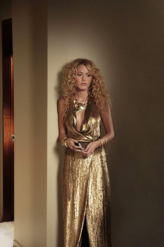 Uno de nuestros looks favoritos. En el episodio de la temporada 2 “The Grandfather: Part II”, Serena usa un deslumbrante vestido dorado de lamé diseñado por Diane Von Furstenberg. El dress presenta un escote halter, dejando al descubierto sus delicados hombros y brazos; este cae en un efecto de cascada sobre la parte inferior de su cuerpo. No podemos dejar detrás su icónico peinado: unas ondas voluminosas que caen en sus hombros, dando un aire de <i>glamour disco</i> al look.