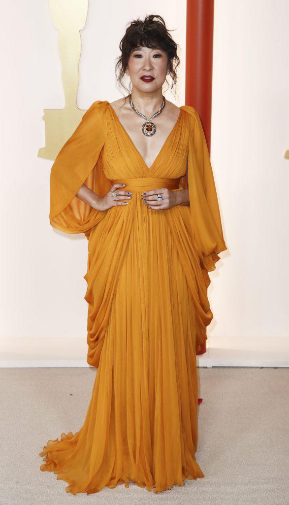 Sandra Oh. La reconocida actriz de la serie <i>Grey’s Anatomy</i>, llegó con un vestido amarillo combinado con labios rojos.