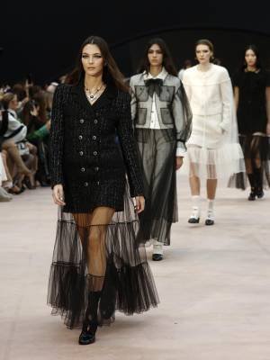 La Semana de la Moda de París anuncia un invierno sofisticado y glamoroso. Como un teatro de ilusiones oníricas, la colección Prêt-à-Porter Otoño-Invierno 2025/26 de CHANEL, presentada por el Estudio de la Creación, juega con escalas de tamaño, longitud y proporción. Bajo el techo de cristal del Grand Palais, una instalación diseñada por el escenógrafo Willo Perron y con una cinta negra como telón de fondo monumental, la colección se inclina hacia puntos de referencia y altera las percepciones.