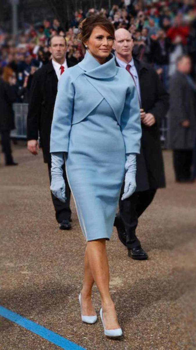 En el día de la investidura de su esposo, Melania Trump sorprendió con un elegante conjunto azul celeste de <b>Ralph Lauren</b>, inspirado en el icónico estilo de Jackie Kennedy. La chaqueta de cuello alto, la falda midi y los guantes de piel a juego evocaron de inmediato la elegancia de los años 60, logrando un guiño claro a la sofisticación clásica que caracterizó a Jackie, marcando así su entrada a la Casa Blanca con un estilo memorable y lleno de tradición.