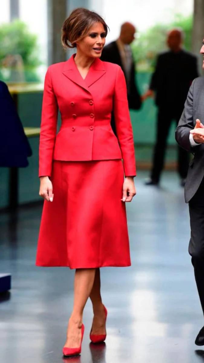 Melania Trump y su esposo viajaron a París en julio de 2017 para reunirse con el presidente francés, Emmanuel Macron, y su esposa, Brigitte. Durante este viaje, aprovechó para rendir homenaje a la alta costura francesa. En su recorrido por el Hospital Necker, estrenó un conjunto de sastrería rojo de Dior, que presentaba la silueta “New Look” característica de la marca, con una cintura ceñida que realzaba su figura de reloj de arena. Completó el look con tacones de aguja a juego, de Christian Louboutin, reafirmando su gusto por el lujo y la sofisticación.
