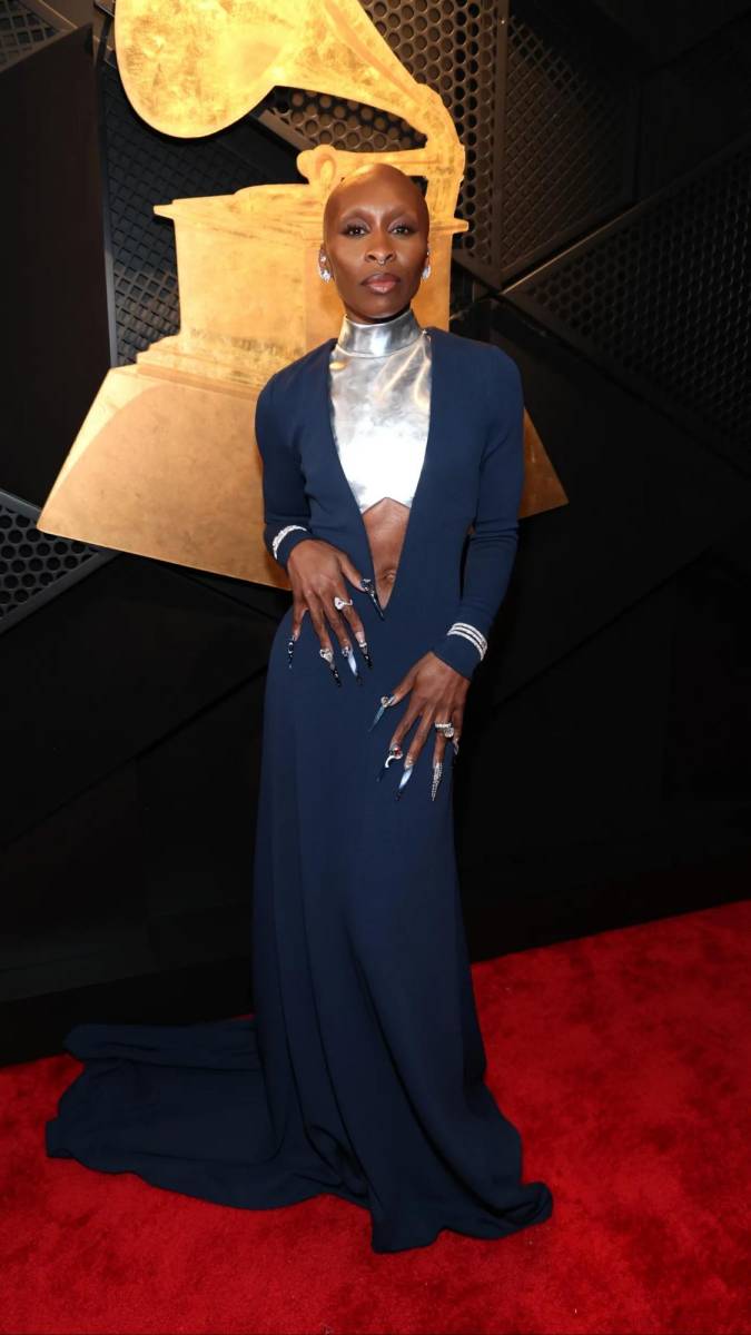 <b>Cynthia Erivo</b> se robó miradas con un vestido vanguardista en azul marino, adornado con impactantes detalles plateados que jugaban con la luz en cada movimiento. La estructura arquitectónica del diseño, con cortes asimétricos y volúmenes audaces, reflejaba su poderosa presencia, fusionando arte y alta costura en un solo look. 