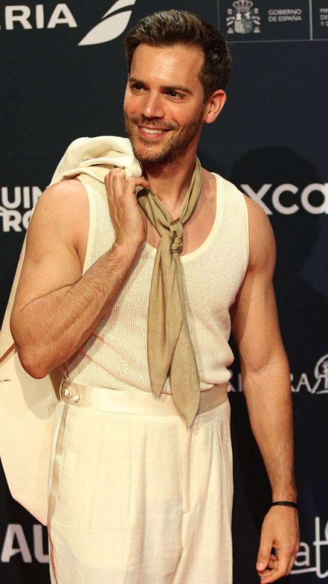 Marc Clotet, el actor ha llamado la atención por su original look, de estilo soft. Su traje, en lino crudo, se combina con camiseta de tirantes y pañuelo al cuello, un complemento que sustituye a la corbata. Un diseño de la casa Pedro del Hierro.