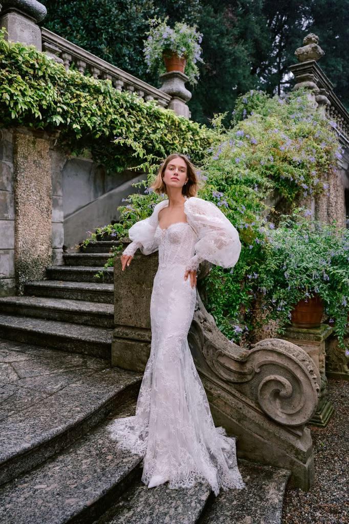 Vestido con corpiño corsé sin tirantes de encaje chantilly., combinado con una chaqueta de encaje chantilly con mangas abullonadas.
