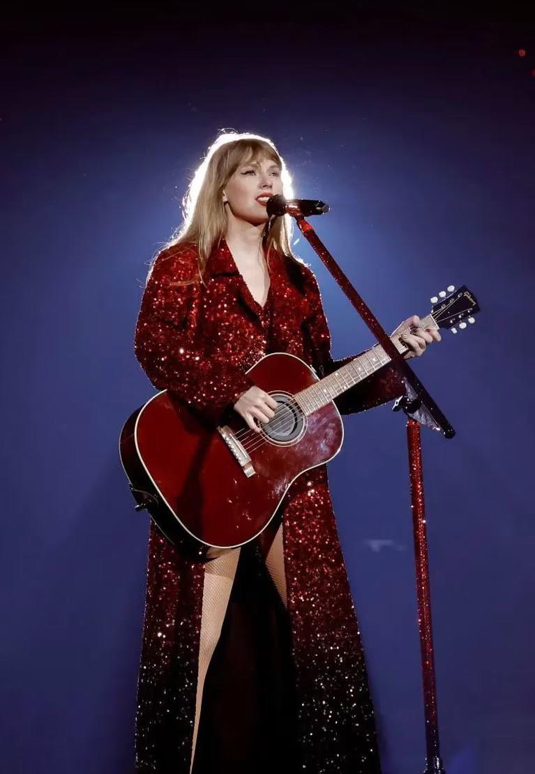 Burning red! Este precioso look de chaqueta larga de lentejuelas rojas y body de joya personifica a Taylor en toda su expresión.