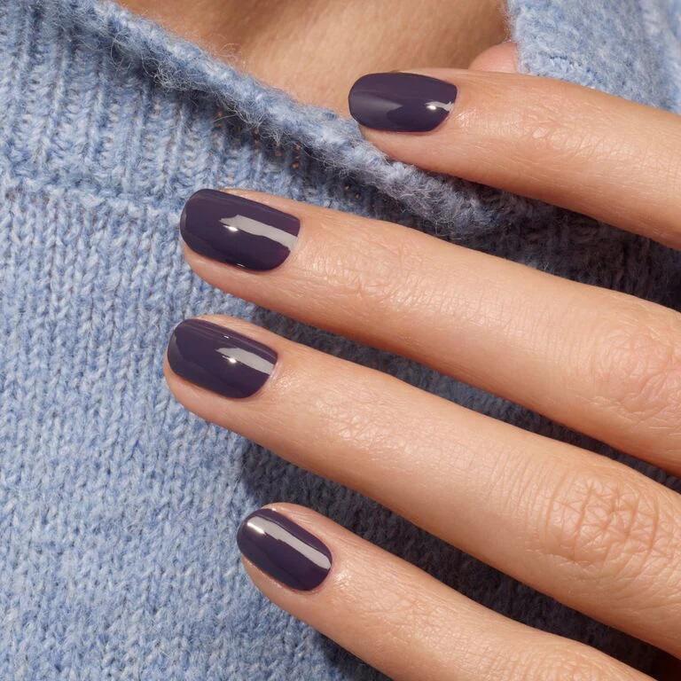 El esmalte violeta. Un precioso morado oscuro que está adornado sin fuerza.