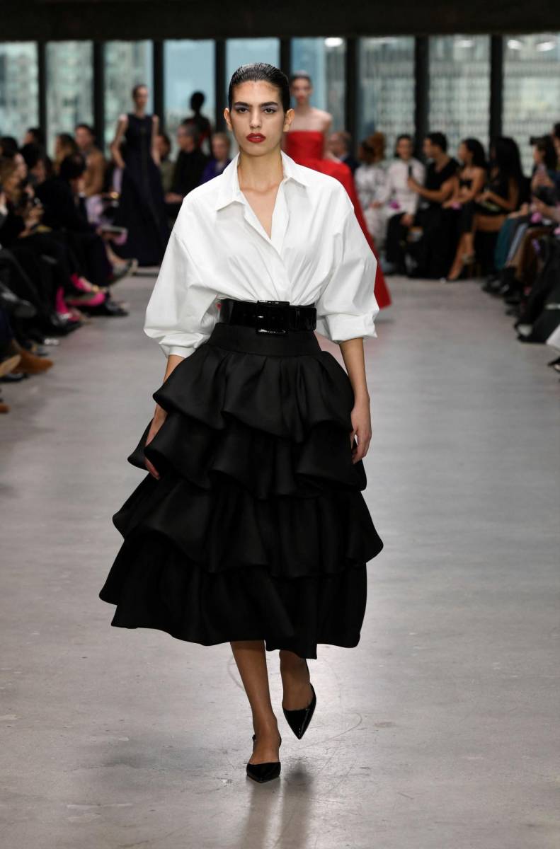 No faltaron los clásicos que hacen inconfundible a la casa neoyorquina: falda lápiz o con volantes o pantalón negro pitillo o ancho con blusa blanca, mangas abullonadas o con volantes, vestidos palabra de honor, trajes de chaqueta de cuadros negros y blancos o con mangas inspiradas en los kimonos japoneses con mucho volumen cosidas en un punto de la parte superior que confiere a la prensa el volumen de una pieza arquitectónica.