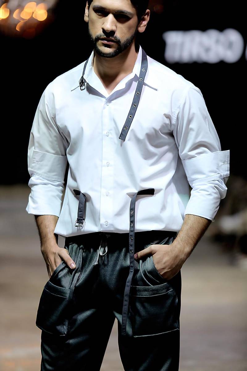 La clásica button down shirt se renueva con detalles como correas de hebillas metálicas en gris, un pop de modernidad al armario clásico masculino.