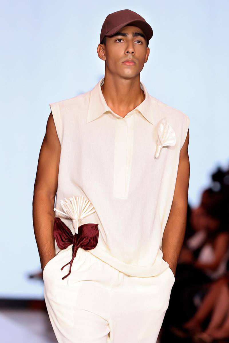 La colección de Rubio florece como un jardín en movimiento. Cada pieza está cobra vida con delicadas flores de tela elaboradas a mano, superpuestas una a una hasta formar composiciones que evocan especies botánicas reales.