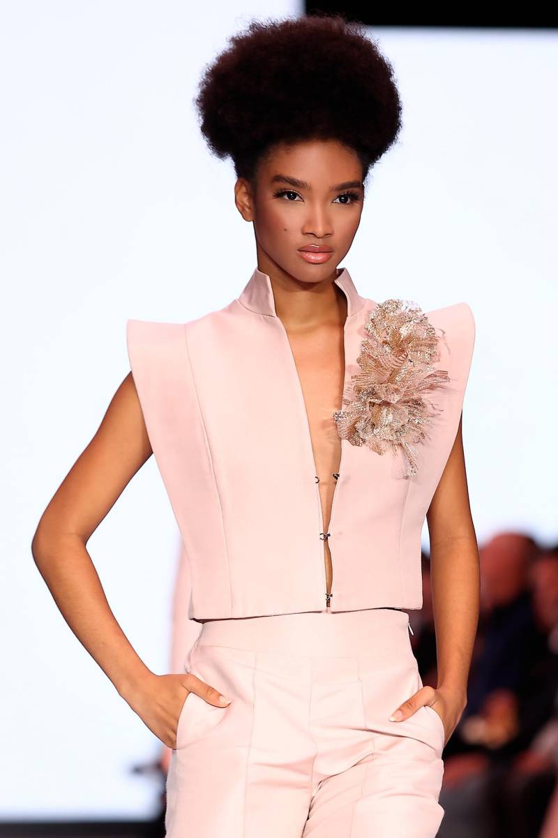 Noguera le da nuevas formas a su broche insigne, revistiéndolo de lujo con detalles de brillo, a tono con sus prendas teñidas de coral