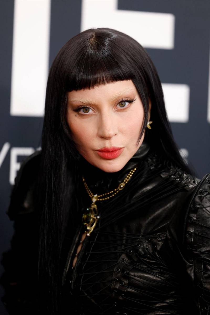 <b>Lady Gaga</b> apostó por un look gótico y vanguardista, con cejas desvanecidas que resaltaban su mirada intensa. Un delineado sutil acompañó sus labios rojos aterciopelados, creando un contraste dramático con su melena negra y flequillo recto.