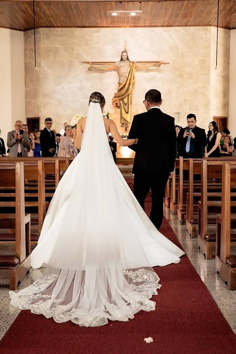 La novia desfiló del brazo de su padre, Gustavo Castillo, sobre la alfombra roja extendida en el pasillo principal de la iglesia